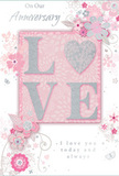 This anniversary card offers a gentle tribute to lasting romance, its design unfolding with the soft intimacy of a quiet evening walk through Ickenham. At the heart of the card, the word "LOVE" is spelled out in raised, soft glitter, each letter glowing with pastel pinks and silvery greys. The "O" is replaced by a shimmering silver heart, textured in such a way that it appears almost three-dimensional, like a small charm nestled among petals in a romantic bouquet. Surrounding this central motif, delicate blooms in blush, mauve, and creamy ivory seem to unfurl across the card in loose, watercolour-style strokes. The petals appear soft and translucent, evoking the tender beauty of freshly cut flowers chosen for a special anniversary delivery. Fine lines outline the blooms and leaves, with graceful swirls and tiny flourishes weaving between them, adding movement and a hint of whimsy-as if a breeze had drifted in from Swakeleys Park and set the flowers gently in motion. Subtle butterflies and miniature petals are scattered through the design, drawing the eye around the composition without overwhelming it. The backdrop is a muted pink wash, soothing and calm, allowing the floral art and glittered lettering to stand out. Elegant, understated script at the top and bottom of the card reads "On Our Anniversary" and "I love you today and always," the writing poised and gentle, like words shared across a dinner table at home. The whole card carries a soft, reflective glow, making it feel like a tender keepsake for honouring a shared journey in Ickenham, full of cherished memories and quiet affection.
